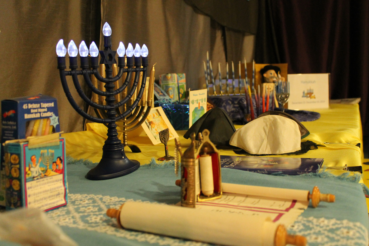 a table topped with a menorah, candles, and other items for Hanukkah